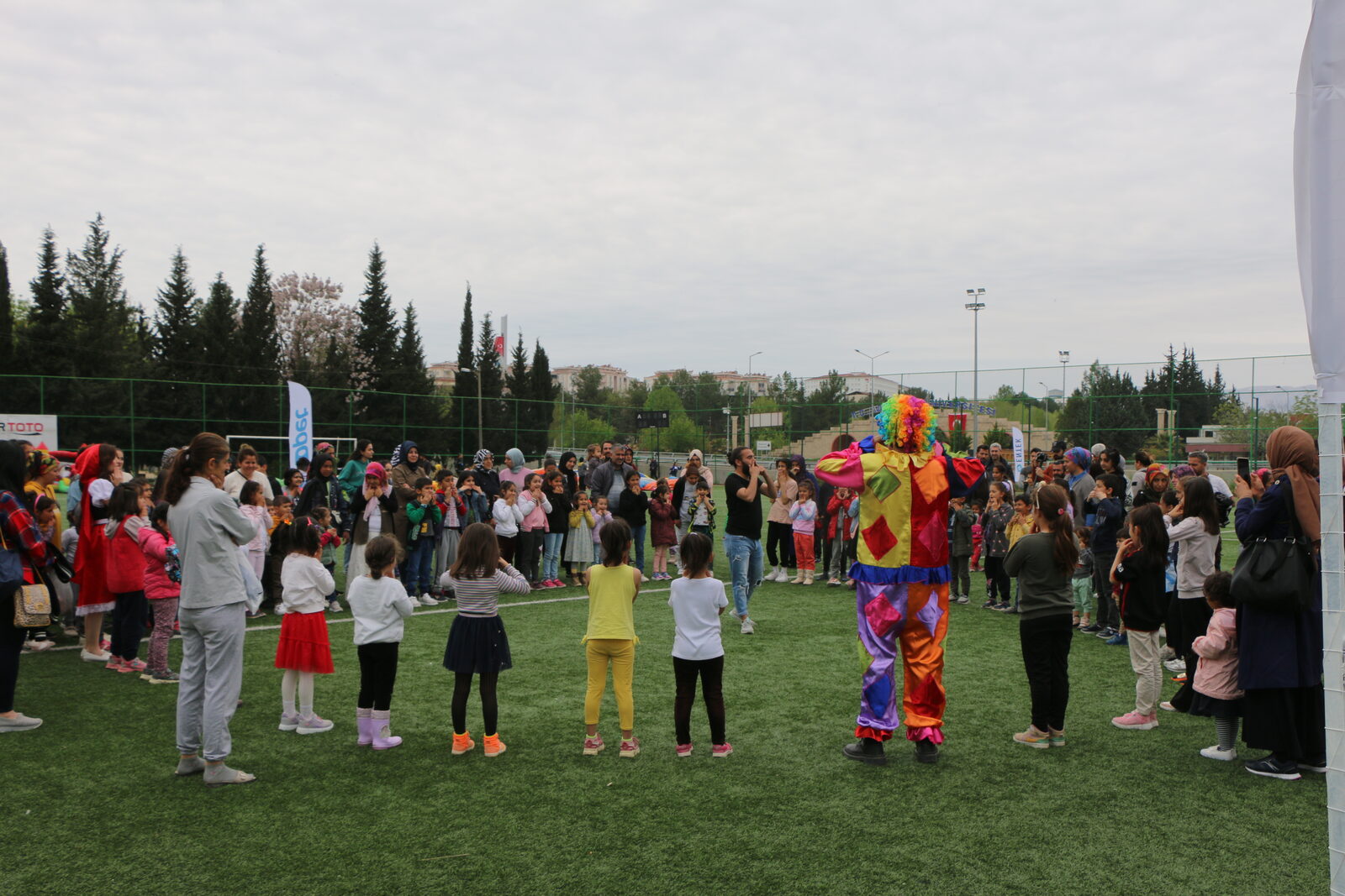 Sahada maskot eşliğinde toplanan çocuklar