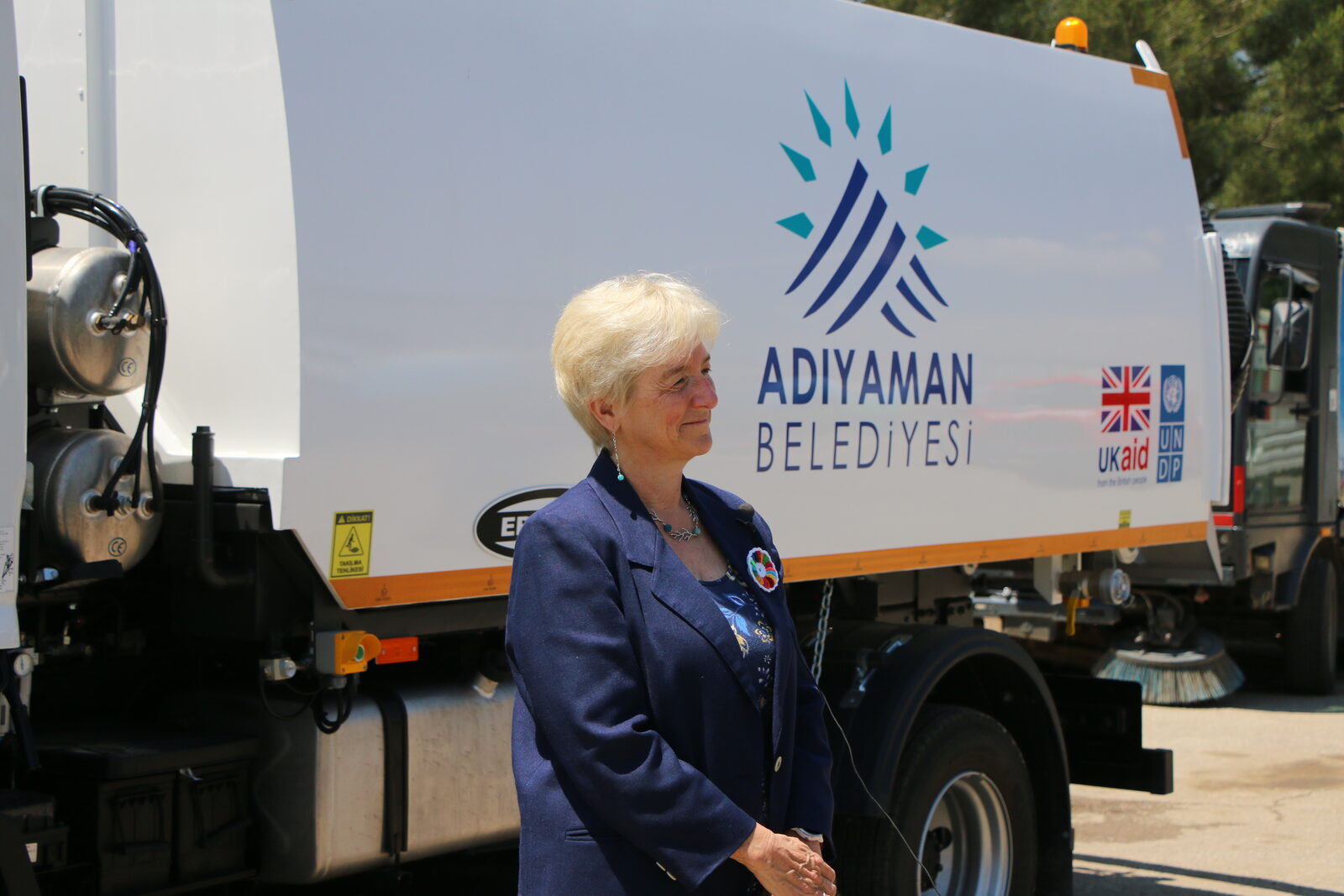 UNDP Türkiye Mukim Temsilcisi Louisa Vinton, Adıyaman Belediyesi'ne bağışlanan yol süpürme aracının yanında